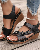 Tinaya – Sandalen Mit Keilabsatz Und Blumenmuster in Schwarz