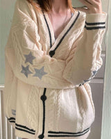 Damen nan oversized Zopfmuster-Cardigan mit V-Ausschnitt, Knopfleiste und Sternapplikationen Drune in Apricot-Schwarz