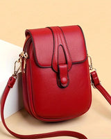 Kompakte Damen-Umhängetasche aus Leder mit minimalistischem Design und verstellbarem Riemen. in Rot