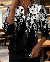 Brisella - Florale Bluse mit Reißverschluss in Schwarz