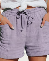 Damen Shorts mit elastischem Bund und Kordelzug sowie aufgesetzten Taschen und umgeschlagenen Säumen in Lila