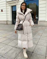 Lange Damenpufferjacke mit Gürtel und hohem Kragen in Beige